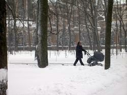 A mother walking with a baby carriage in a St. Petersburg park